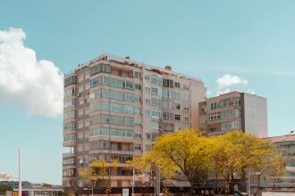 Edifício residencial contemporâneo em Lisboa, fotografado contra um céu azul.