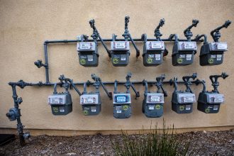 Contadores de gás instalados numa parede exterior de um edifício urbano