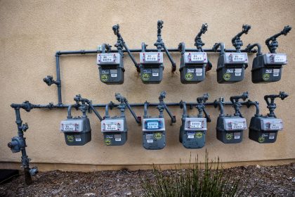 Contadores de gás instalados numa parede exterior de um edifício urbano