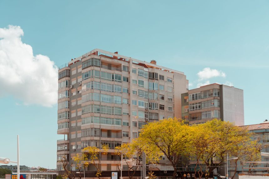 Edifício residencial contemporâneo em Lisboa, fotografado contra um céu azul.