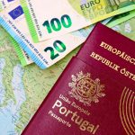 Passaportes português e austríaco sobre um mapa da Europa, acompanhados por notas de euro.